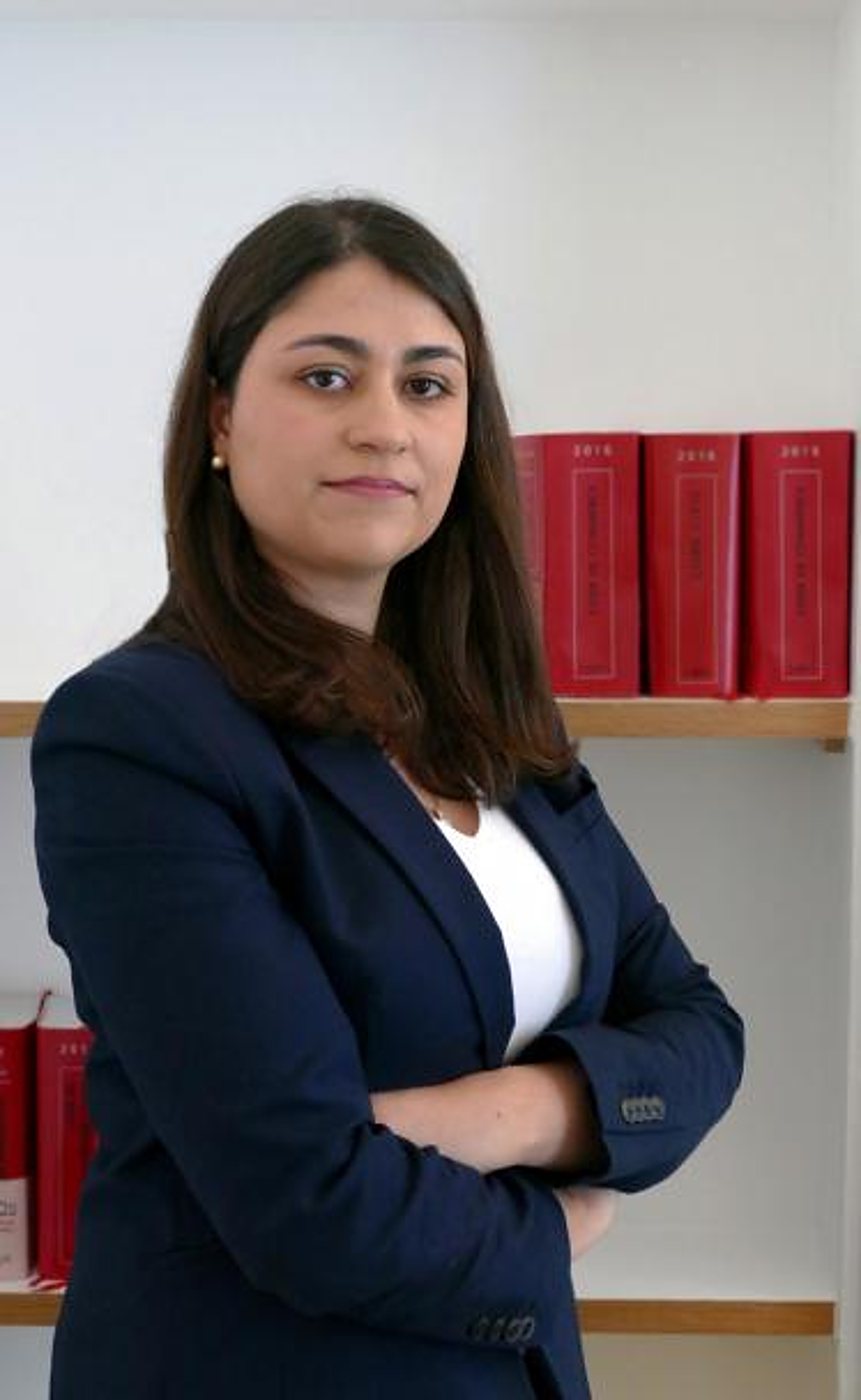 Carina Coelho, avocate, devant une étagère de codes